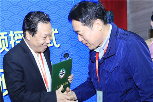 6、中华木工委专家委员会主任张德祥（右）为曹兆庭（左）颁授“中华高级木作师”荣誉